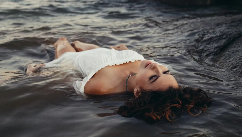 MatureSexMeet: girl reclining in water, embodying tranquility and grace, surrounded by liquid tranquility
